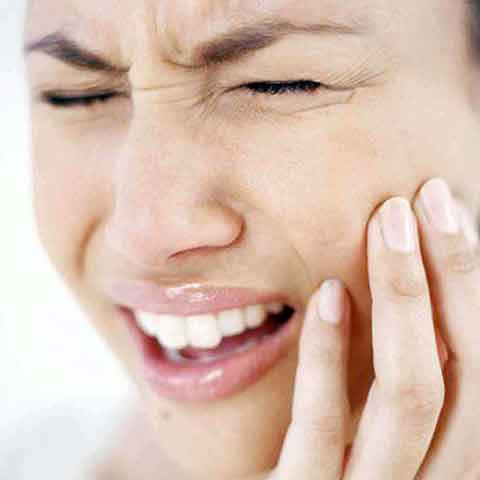 Лицо девушки исказилось в гримасе от повышенной болевой чувствительности зубов